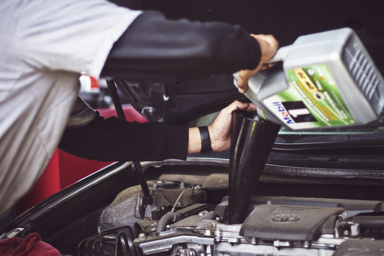 Mechanic pouring engine oil