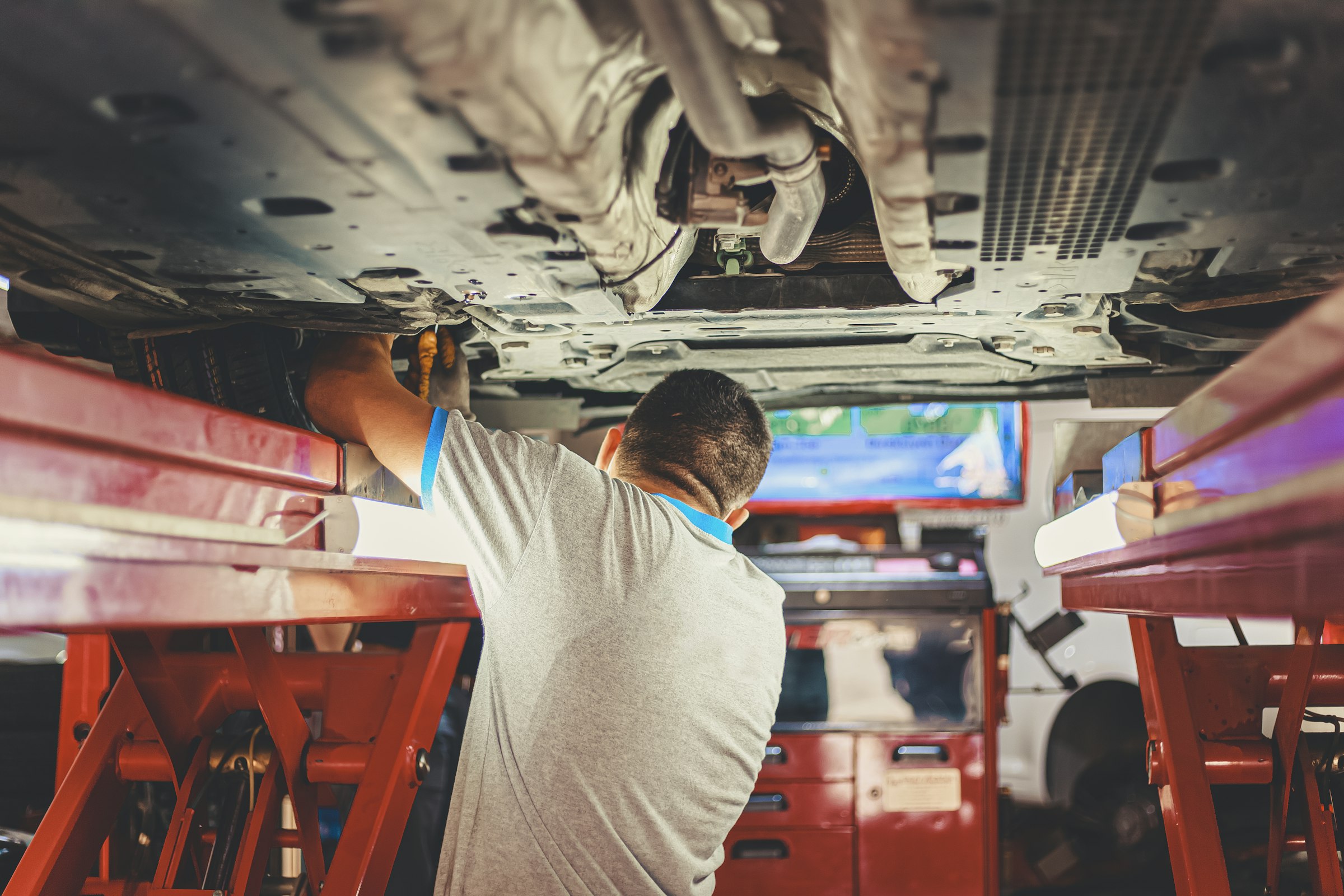 Mechanics working under a car on a lift